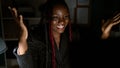 Confident african american woman boss with braids celebrating her business success, while working on a computer in a beautiful Royalty Free Stock Photo