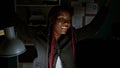 Confident african american woman boss with braids celebrating her business success, while working on a computer in a beautiful Royalty Free Stock Photo