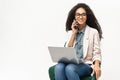 Confident African-American woman in smart casual wear using laptop and talking on the smartphone isolated on white Royalty Free Stock Photo