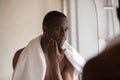 Confident african american young man looking in mirror after shower. Royalty Free Stock Photo