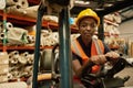 Confident African female forklift operator working in a storehouse