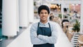 Confident African 30s restaurant worker biracial guy strong position standing indoors barman seller waiter in apron