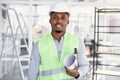 Confident afro-american man in hardhat standing indoors