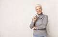 Confident aged businesswoman holding glasses looking at camera