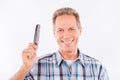 Confident aged man holding a comb