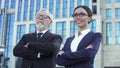 Confident aged and young business partners with crossed arms near office center Royalty Free Stock Photo