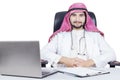 Confident Arabian doctor with laptop on desk Royalty Free Stock Photo