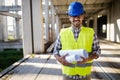Architect holding rolled up blueprints at construction site Royalty Free Stock Photo
