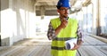 Architect holding rolled up blueprints at construction site Royalty Free Stock Photo