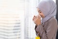 Confident Asia Muslim Islam businesswomen executive working in the modern office drinking a cup of coffee standing beside of