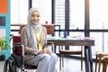 Confident Asia Muslim Islam businesswomen executive working in the modern office and sitting on the wheel chair. Feeling smile