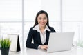 Confident asian businesswoman sitting by desk with laptop in off Royalty Free Stock Photo