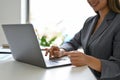 A confident Asian businesswoman using her laptop to manage her business tasks Royalty Free Stock Photo