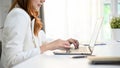 Confident Asian businesswoman using laptop, typing on keyboard, working at her desk in office Royalty Free Stock Photo