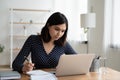 Confident Asian businesswoman working on laptop, writing notes Royalty Free Stock Photo