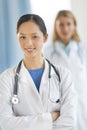 Confident Asian Doctor Standing Arms Crossed In Clinic Royalty Free Stock Photo