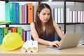 Confident Asian engineer woman with laptop working in workplace of office Royalty Free Stock Photo