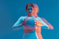 Confident athletic girl basketball player holding ball looking at camera on blue background. Long exposure, motion blur Royalty Free Stock Photo