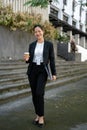 A confident and attractive millennial Asian businesswoman is standing outside of the building Royalty Free Stock Photo