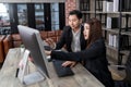 confident attractive secretary present data report to businessman boss. business person sitting and looking at computer monitor