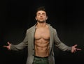 Confident, attractive young man with open jacket on muscular torso