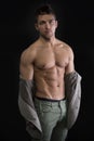 Confident, attractive young man with open jacket on muscular torso
