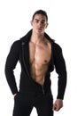 Confident, attractive young man with open sweater on muscular torso