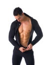 Confident, attractive young man with open sweater on muscular torso