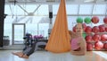 A confident, balding man in aerial yoga exercises , gestures come here