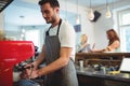 Confident barista using coffee maker at cafe Royalty Free Stock Photo