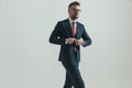 Confident bearded man with glasses buttoning elegant suit Royalty Free Stock Photo
