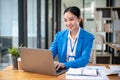 A confident Asian businesswoman is managing her work on her laptop at her desk Royalty Free Stock Photo