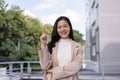 A confident Asian businesswoman is pointing her finger up while standing outdoors Royalty Free Stock Photo