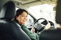 Confident and beautiful. Rear view of attractive young woman in casual wear looking over her shoulder while driving a car Royalty Free Stock Photo