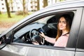 Confident and beautiful young woman in casual wear looking over her shoulder while driving a car Royalty Free Stock Photo