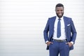 Confident black business man in a stylish suit standing against the wall looking at the camera with copy space Royalty Free Stock Photo