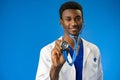 Confident black doctor posing over blue studio background. Royalty Free Stock Photo