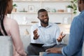 Confident black family counselor talking with married couple, giving advice to spouses Royalty Free Stock Photo