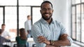 Confident black leader standing at modern company office feeling proud