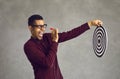 Confident black man aiming dart at shooting target bullseye as metaphor for setting business goal Royalty Free Stock Photo