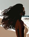 A confident black woman standing tall and proud on the beach her skin glistening in the sun and her long hair blowing in
