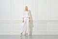 Confident blonde woman in total white look