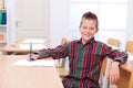 Confident boy sitting alone in classroom Royalty Free Stock Photo