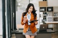 Confident business expert attractive smiling young asian woman holding digital tablet on desk in creative office Royalty Free Stock Photo