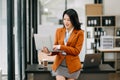 Confident business expert attractive smiling young asian woman holding digital tablet on desk in creative office Royalty Free Stock Photo