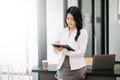 Confident business expert attractive smiling young asian woman holding digital tablet and laptop on desk in office..Confident Royalty Free Stock Photo