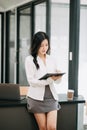 Confident business expert attractive smiling young asian woman holding digital tablet and laptop on desk in office..Confident Royalty Free Stock Photo