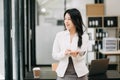 Confident business expert attractive smiling young asian woman holding digital tablet and laptop on desk in office..Confident Royalty Free Stock Photo