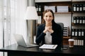 Confident business expert attractive smiling young woman typing laptop ang holding digital tablet on desk in office Royalty Free Stock Photo