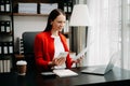 Confident business expert attractive smiling young woman typing laptop ang holding digital tablet on desk in office Royalty Free Stock Photo